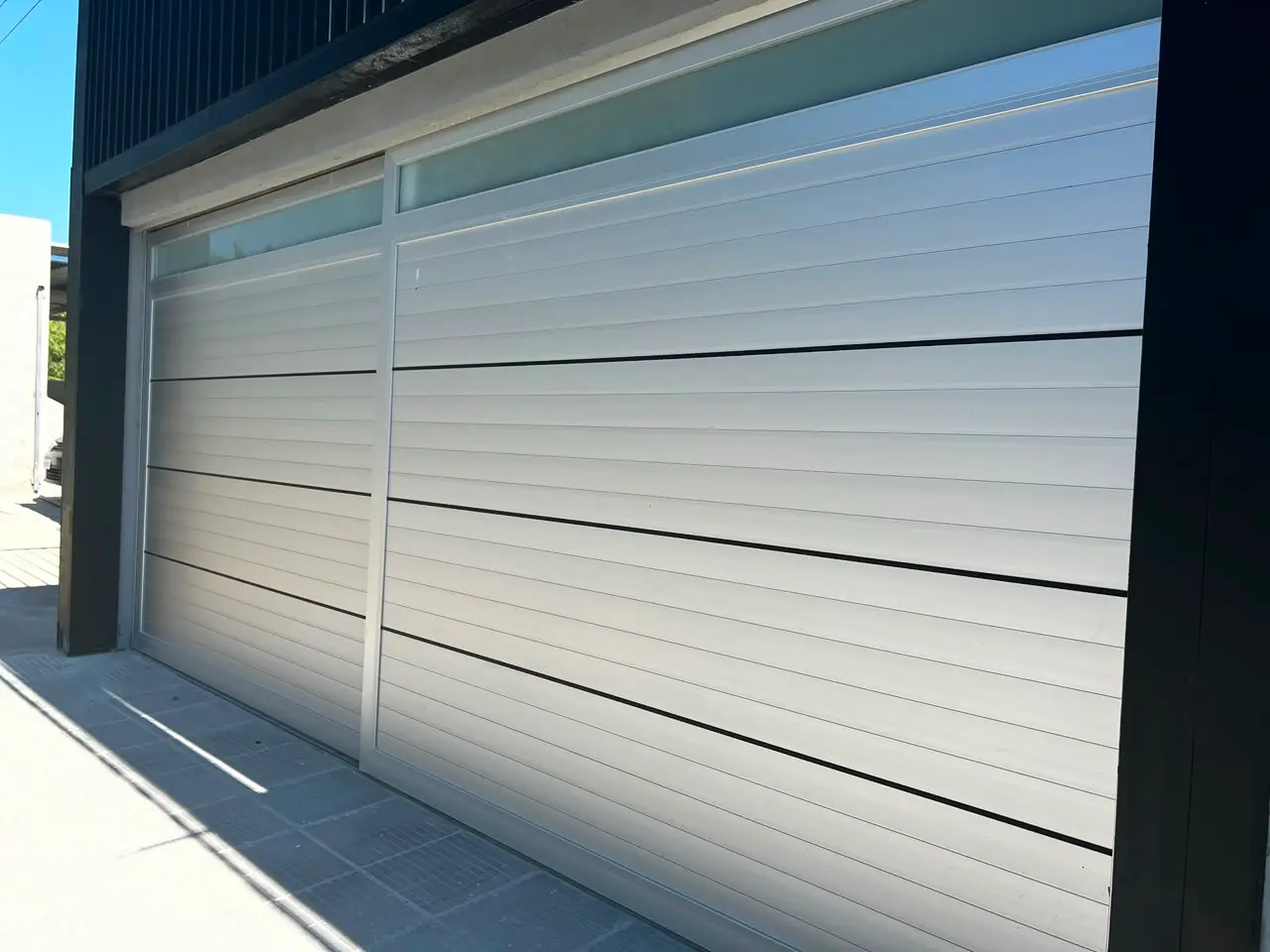 Portón automatizado de aluminio instalado en acceso residencial